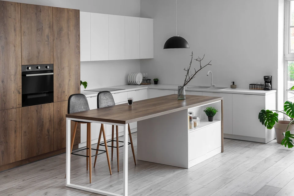 Cuisine moderne avec îlot central et plan de travail en bois, tabourets de bar en cuir gris
