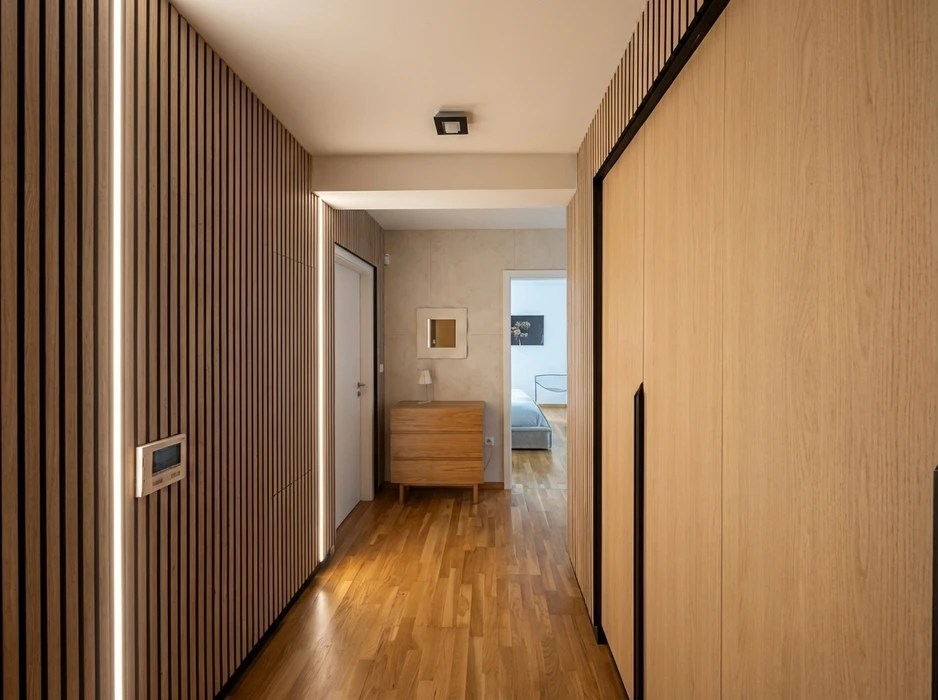 Couloir moderne avec parquet en bois massif, lambris à tasseaux verticaux en chêne naturel, armoire encastrée à portes battantes placage chêne, commode scandinave en bois massif