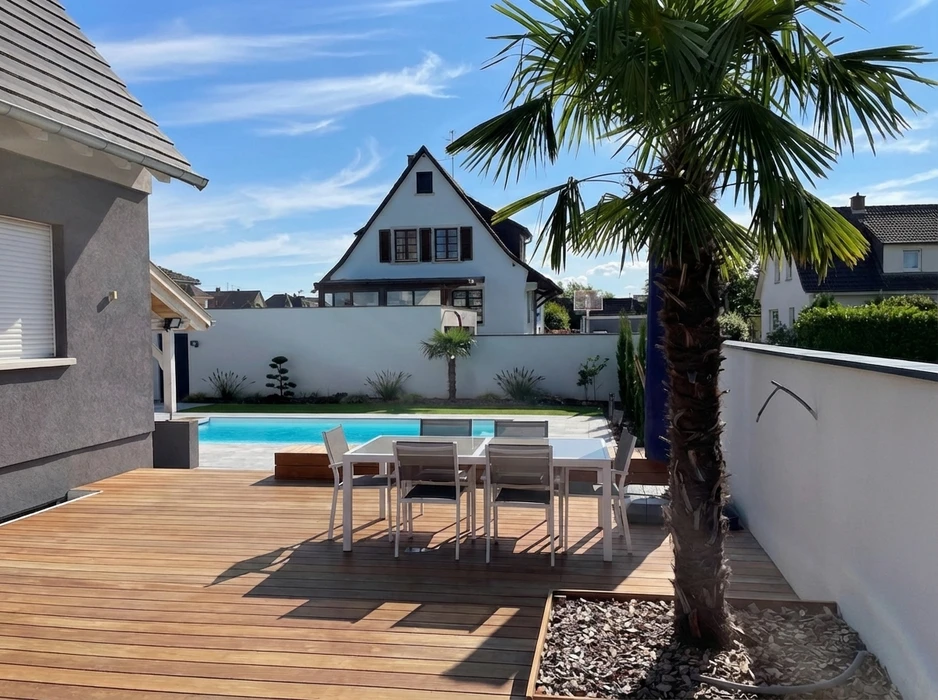 Terrasse en bois composite IPE avec salon de jardin blanc (table + 6 chaises aluminium), piscine rectangulaire à débordement, margelles en carrelage grès cérame