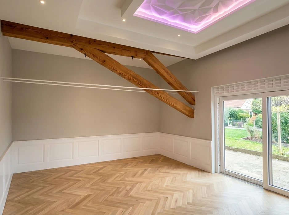 Plancher en bois avec motif parquet à lames rectangulaires de différentes teintes naturelles, alternant tons clairs et foncés dans un agencement géométrique régulier