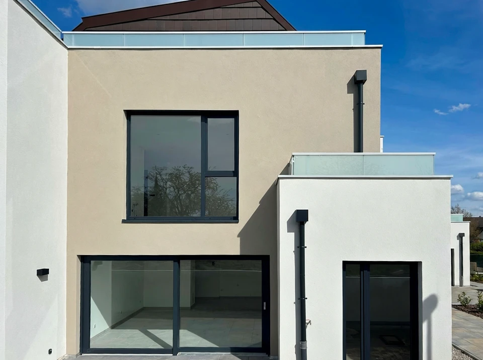 Façade extérieure d'une maison contemporaine neuve, style cubique, enduit minéral bi-ton beige et blanc