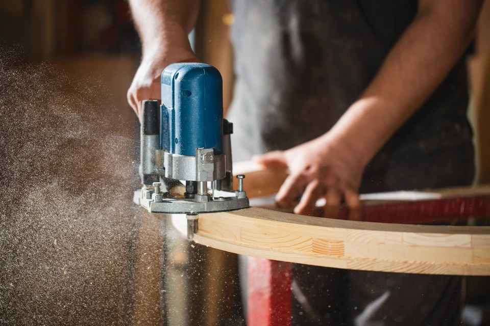 Atelier de menuiserie avec artisan barbu travaillant sur établi en bois massif