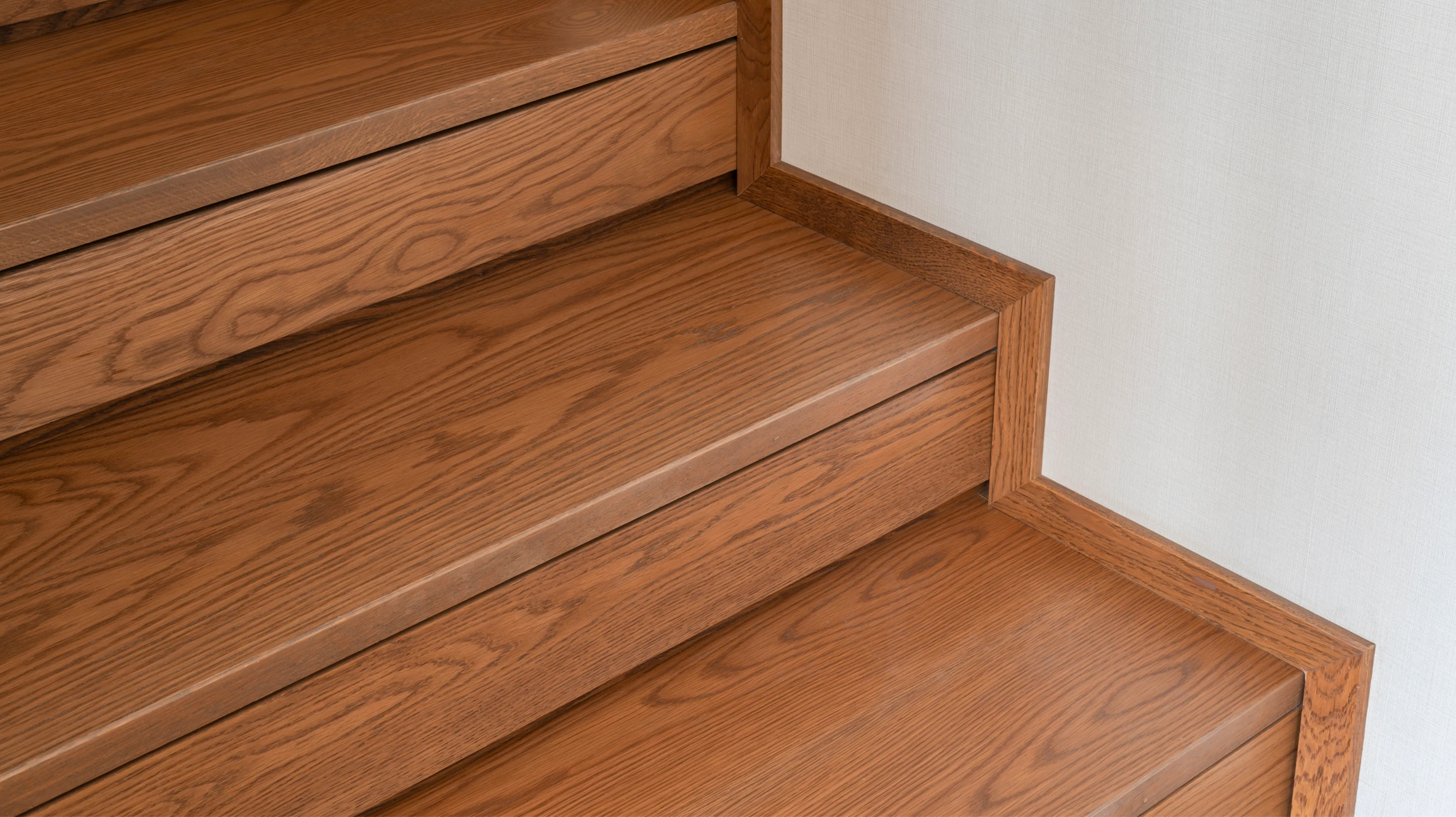 Escalier en bois avec rangements intégrés sous les marches, tiroirs coulissants ouverts révélant l'espace de stockage optimisé