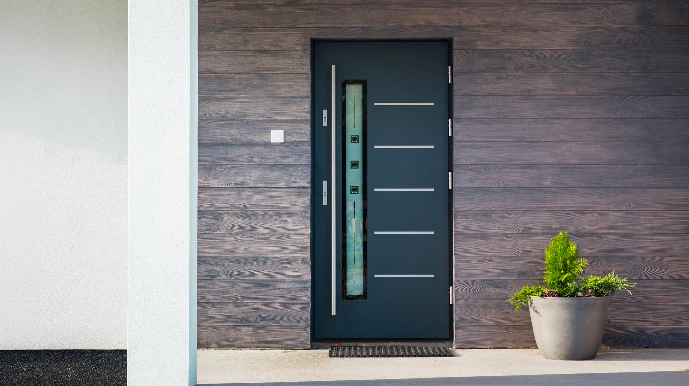 Ouvrier en tenue bleue et casquette installant une porte en bois dans un intérieur résidentiel en construction