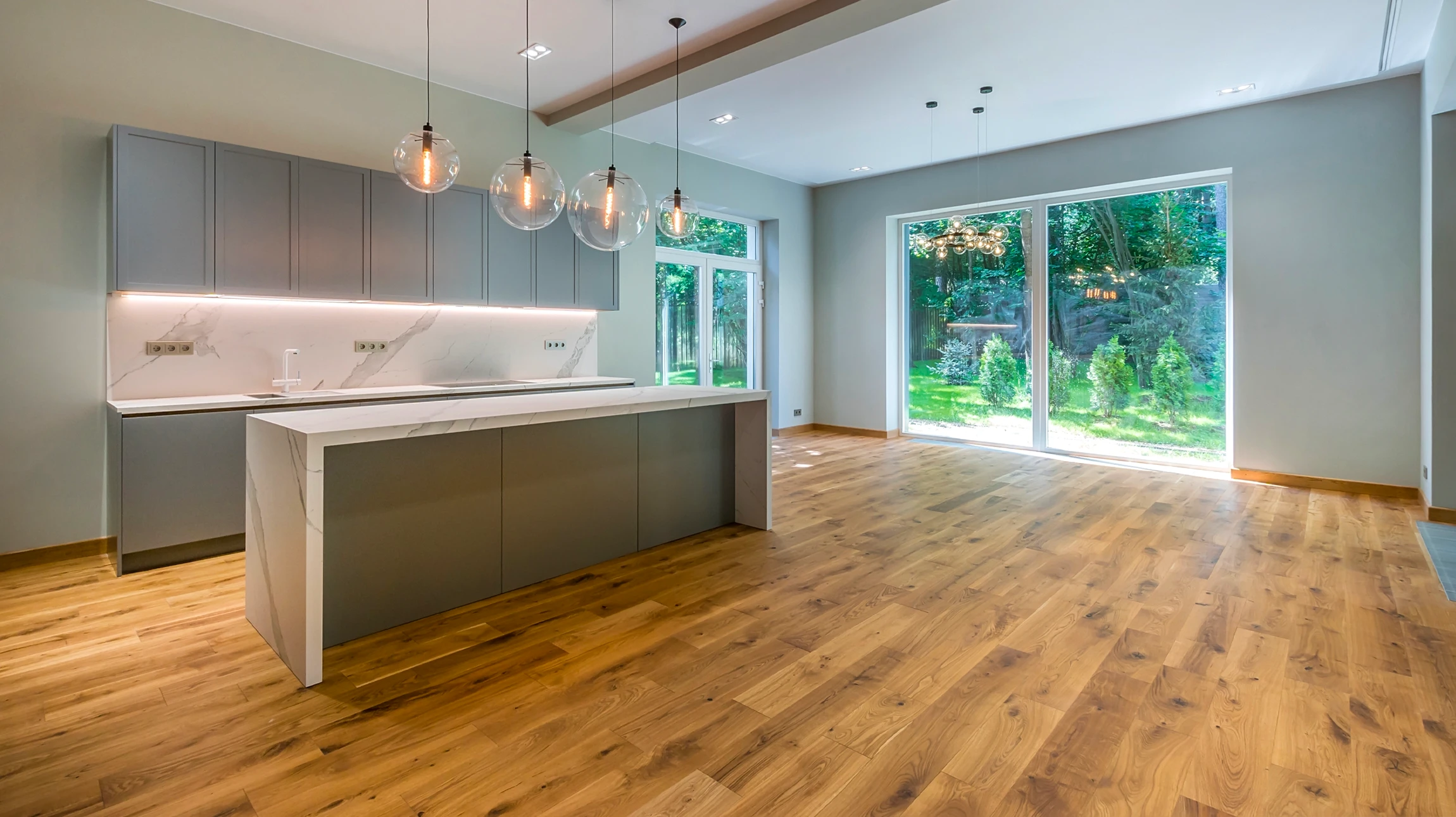 Artisan à genoux installe un parquet en lames de bois sur chantier intérieur